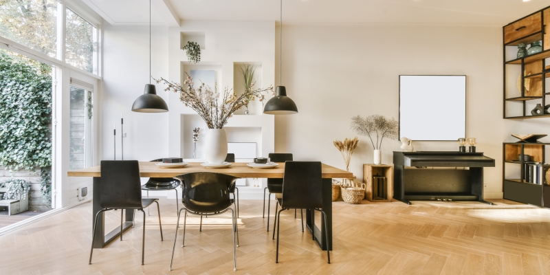 Delightful dining area with wooden table and two hanging lamps above the table
